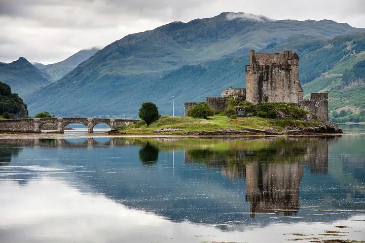 Un château historique en pierre situé sur une île reliée par un pont